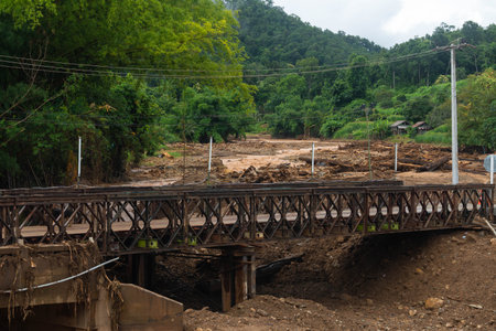 Damaged bridge with debris after flood disaster in rural mountain areaの写真素材