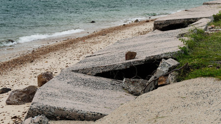 Eroded coastal road infrastructure collapse from sea waves and storm impact.の写真素材