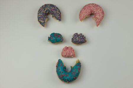 Cheerful face made of donuts on a white background.の写真素材