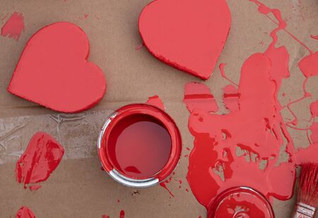 two red hearts and a can with paint and a paint brush on a gray backgroundの写真素材