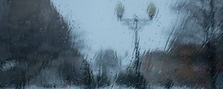 water drops on a car windshield, blurred image of a cityscape