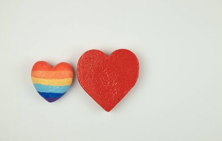 figures of two hearts, lgbt and traditional relationships,white background - red and rainbow colorsの写真素材