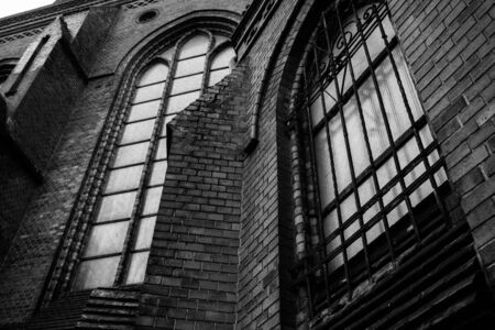 Old gothic church with iron bars on the windows dark moody black and white photography