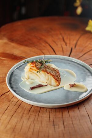 portion of white fish steak with bechamel sauceの写真素材