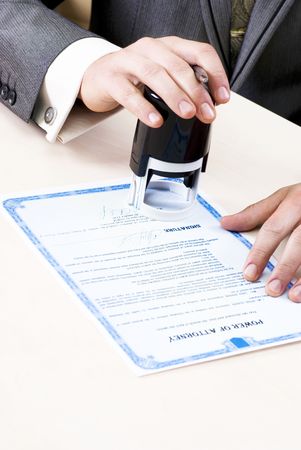 close-up of male hands of the notary stamp on the power of attorney