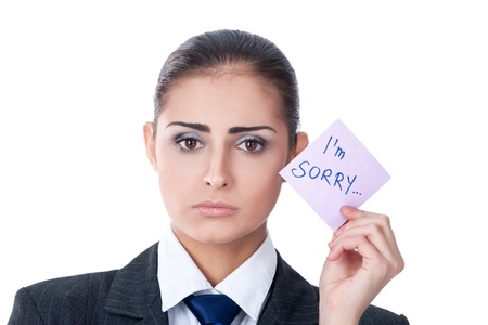 sad young woman holding a note saying "sorry"の写真素材