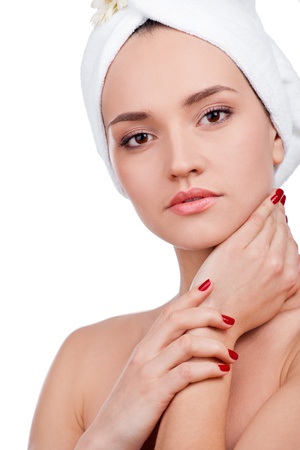 Beautiful woman in towel on head touching her clean face の写真素材
