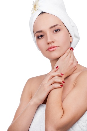 Beautiful woman in towel on head touching her clean face の写真素材