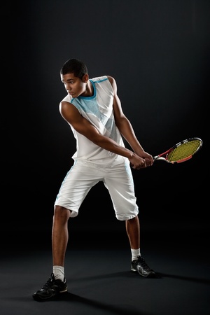 Young tennis player with racket playing tennisの写真素材