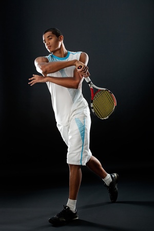Young tennis player with racket playing tennisの写真素材