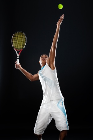 Young tennis player with racket ready to serve a tennis ballの写真素材