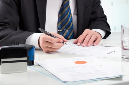 Notary public signing document at his workplaceの写真素材