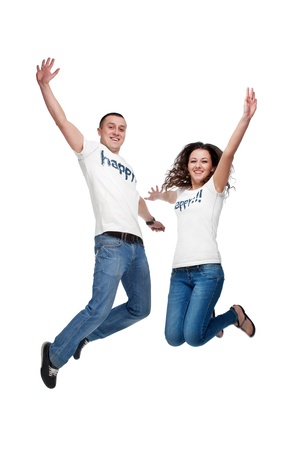 Young happy couple jumping up isolated on whiteの写真素材
