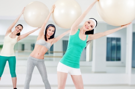 Three girls in fitness club workout with aerobic ballsの写真素材