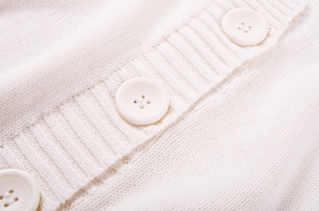 Knitted white jersey texture with a buttonの写真素材