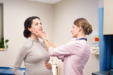 Doctor endocrinologist checking thyroid pregnantの写真素材