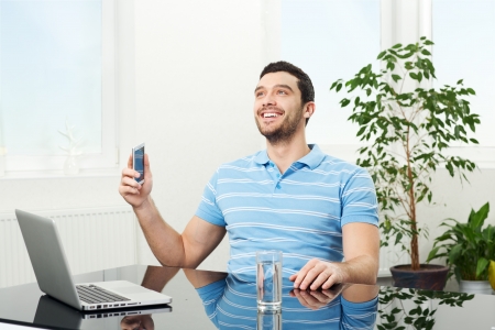 happy businessman holds mobile phone, and enjoy the good newsの写真素材