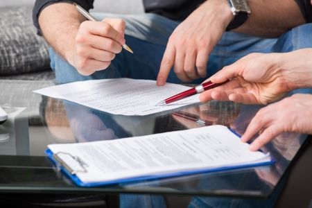 Hands of people signed the document, sitting at the deskの写真素材