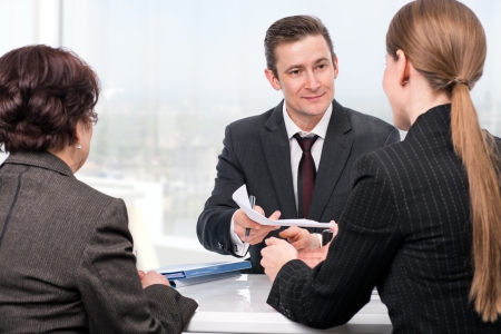 Agent  or notary public  signing documents with with senior woman and her daughterの写真素材