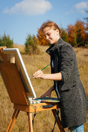 Young painter at work in the mountains with paletteの写真素材
