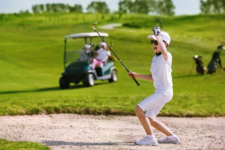 Boy playing golf and enjoing on the successful hitの写真素材