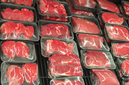 Different types of raw meat in plastic boxes in supermarketの写真素材