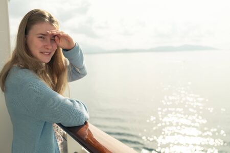 Cruise ship vacation. Teenager girl relaxing on luxury cruise ship balcony. Portrait of a happy beautiful girl on a cruise ship at sunriseの写真素材