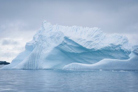 Antarctic icebergs and majestic landscape, cloudy blue skyの写真素材