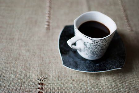 White cup of coffee on a black saucerの写真素材