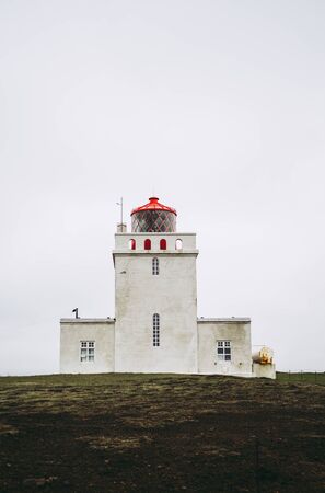 Dyrholaey lighthouse under heavy gray sky. Iceland.の写真素材