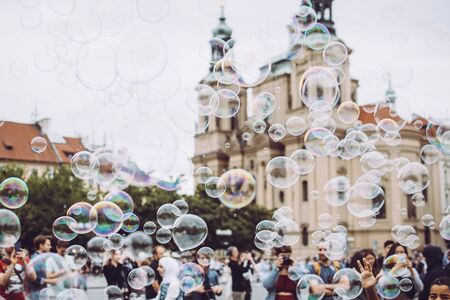 Colorful bubbles flying against the city's Medieval architecture. Tourists enjoy their stayの写真素材