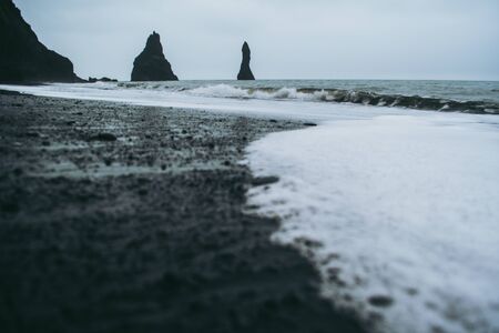 Black sand and white oceanic water on Reynisfjara beach, Icelandの写真素材