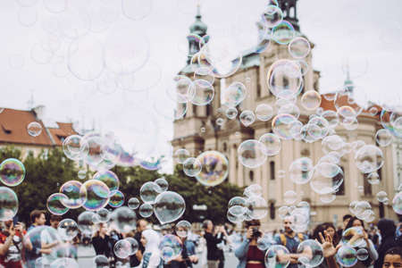 Prague, Czech Republic - August 17, 2019: Colorful bubbles flying against the city's Medieval architecture. Tourists enjoy their stayのeditorial素材