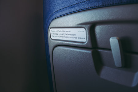 Fasten seat belt while seated sign on the back of a seat, translate into Ukrainian and Hungarian...