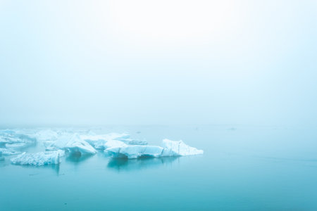 Misty glaciers in the blue waters of Jokulsalron glacial lake in Icelandの写真素材