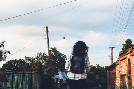 Modern woman riding her electric scooter on a village roadの写真素材