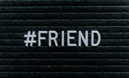 Hashtag word # friend written on the letter board. White letters on the black background.の写真素材