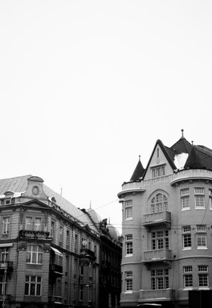 Black and white facades of the architectural old houses in the city center of Lviv, Ukraine. Pale winter sky on the background. Black and whiteの写真素材