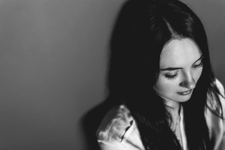 Pretty pale brunette looking in the distance with her beautiful dark eyes partly closed. Atmospheric...