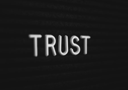 Word trust written on the letter board. White letters on the black backgroundの写真素材
