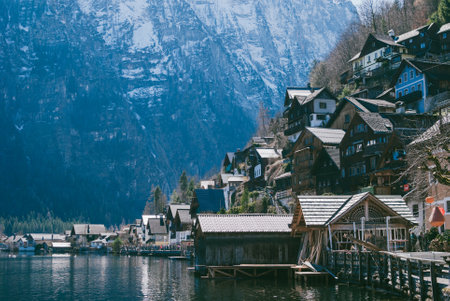 Panoramic view of Hallstatt village located in Austria against white rocky mountains. Black roofs of the houses located throughout the hillの写真素材