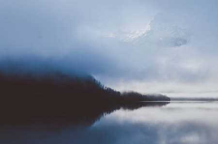 Delightful landscape view of Austrian Alps. Blue sunset over the early morning river covered with...