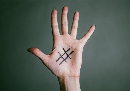 Black hashtag marked on girl's tender pale palm of hand. Close-up. Concept (idea) of the Internet,...