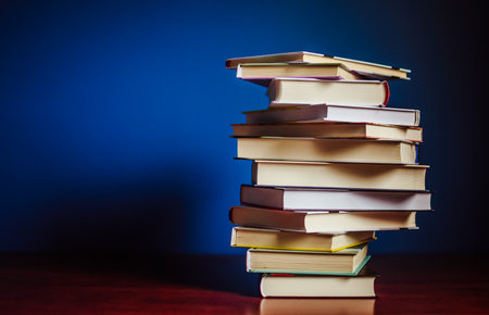 Tower of colorful books on the table. Closeup of pages. Abstract concept of knowledge, education,...