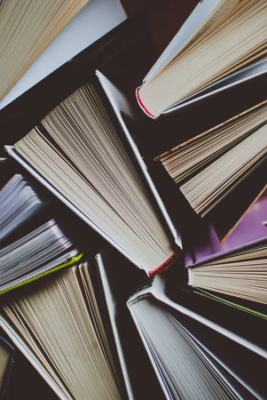 Open new colorful books standing on the wooden table. Closeup of pages. Abstract concept of...