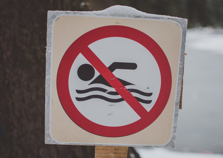 "No swimming" covered with snow near winter lake in the mountainsの写真素材