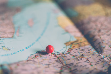 Closeup of a traveler's road map in vintage retro colors. Countries and cities of Western Europe on the map. Red push pins marking Gdansk, Polandの写真素材