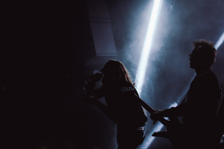 A singer and a guitarist performing on a stage during their band's live club showの写真素材