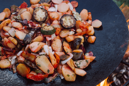 Roasting vegetables in outdoor. Preparation of food on a fireの写真素材