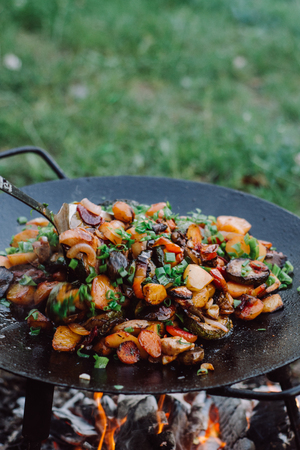 Roasting vegetables in outdoor. Preparation of food on a fireの写真素材
